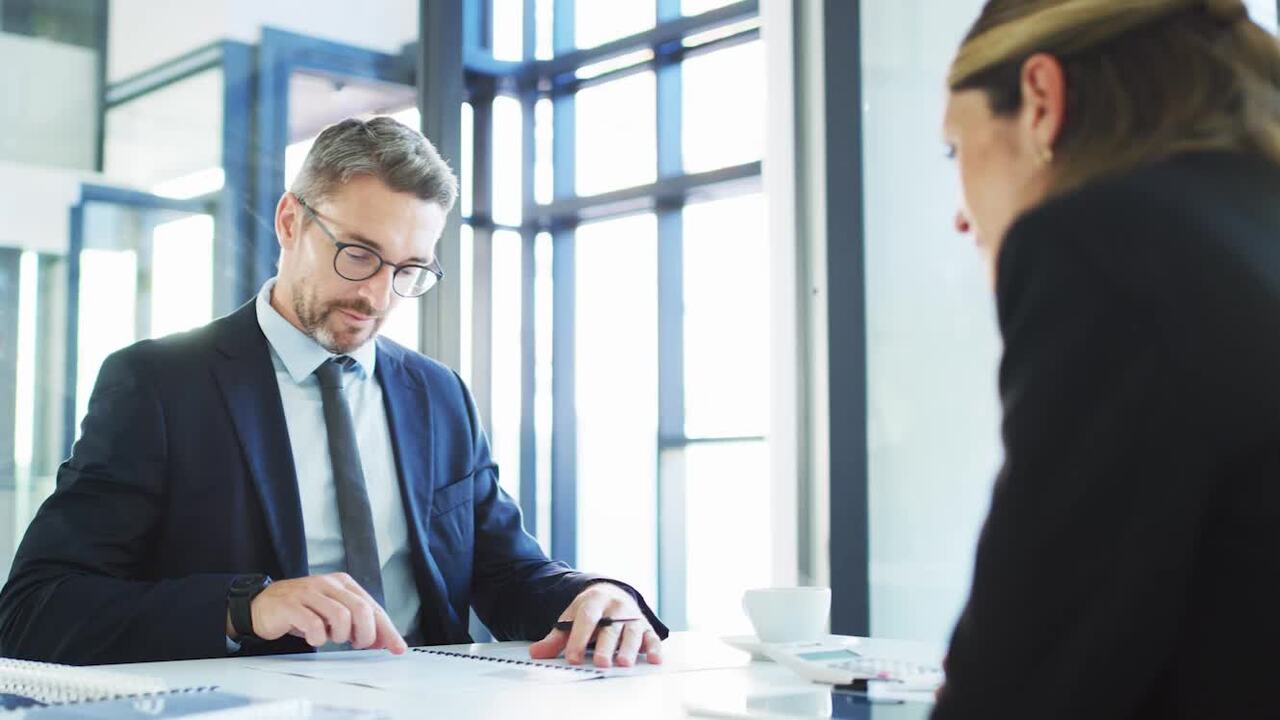 Un homme en costume montrant un document en face d'une femme